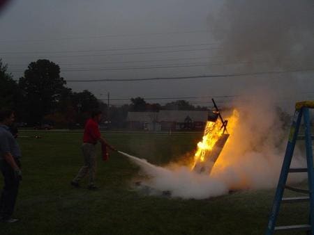 Fire extinguisher training outdoors at dusk.